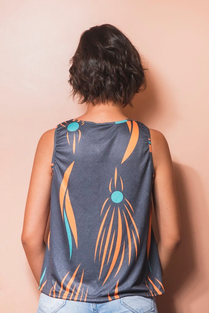Woman with short hair wearing a patterned top with geometric design, back view.